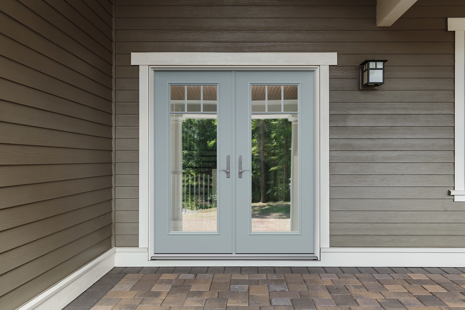 Exterior view of double entry doors that are light blue with large glass panels in each. The entire door is frame by white wood.