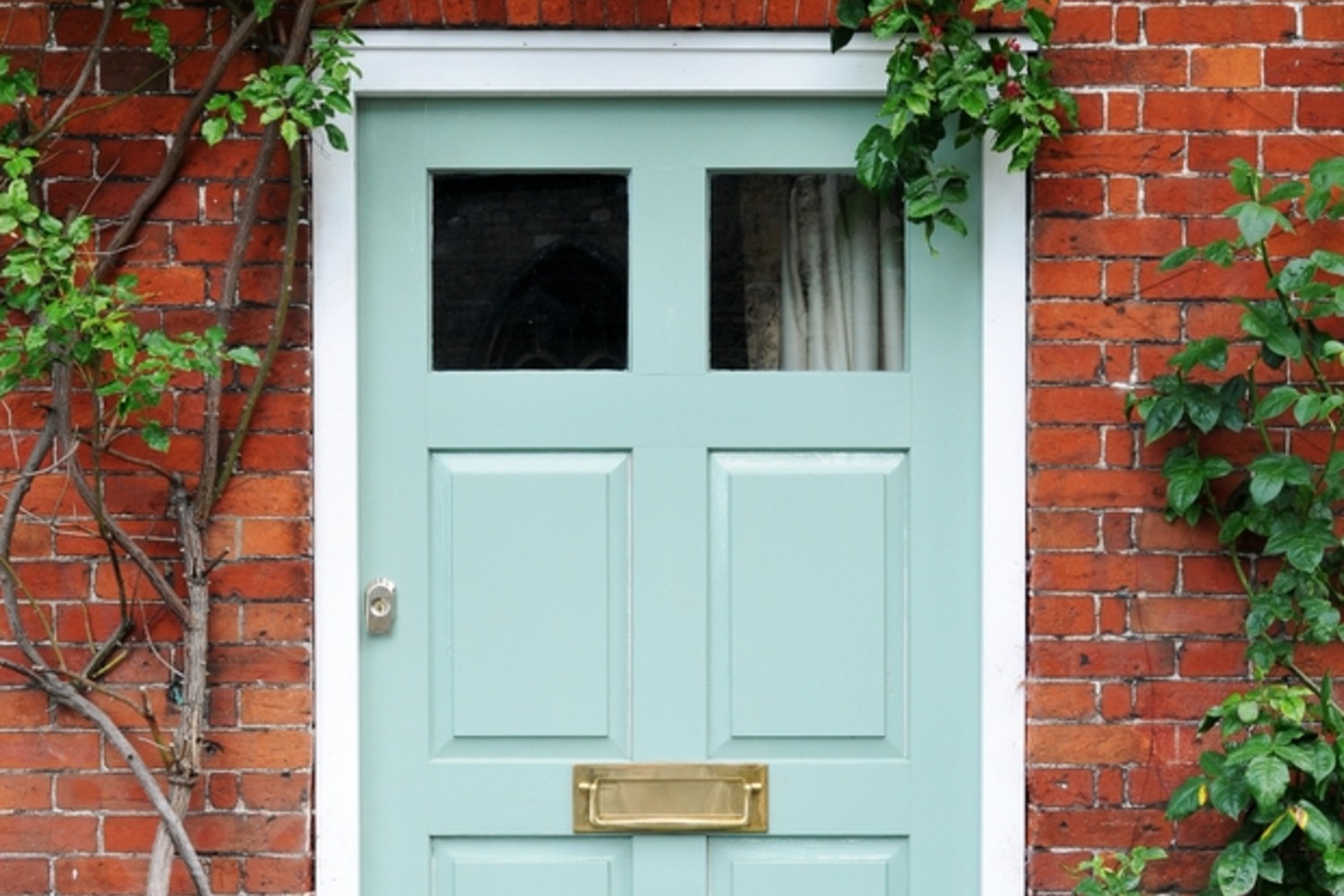 Mint green front door in a brick exterior home.