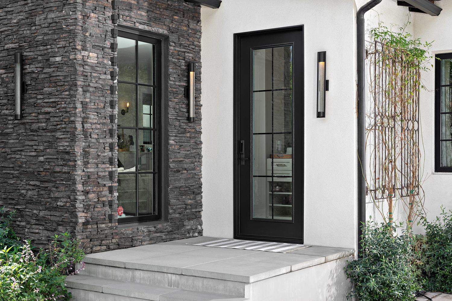 Exterior view of Laurie March's front door. It is black with Glass slats in the middle.