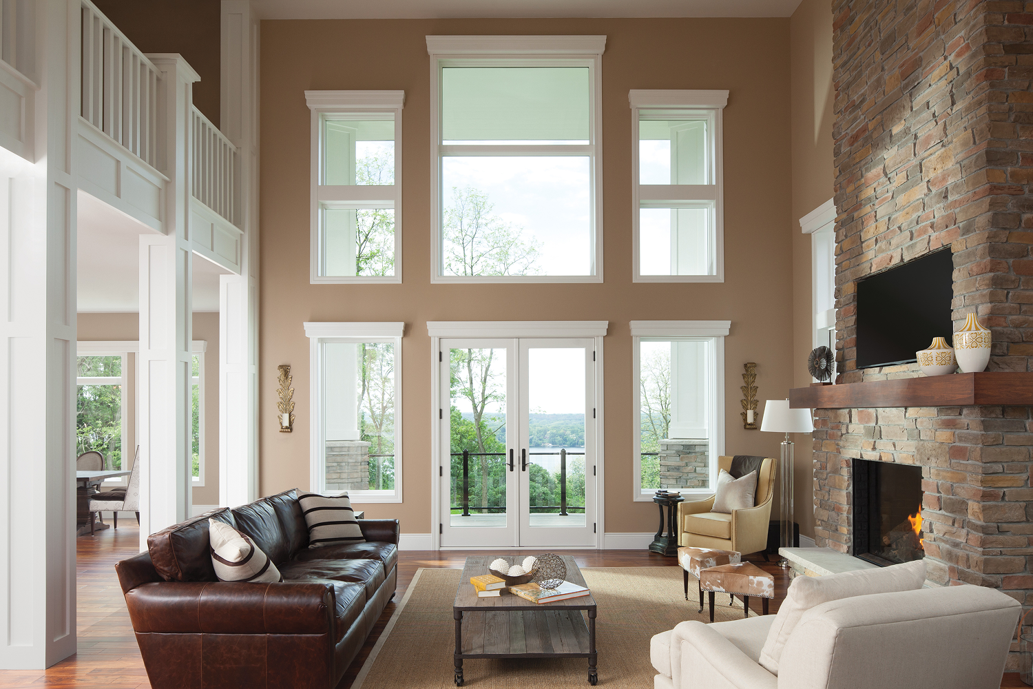 Andersen 400 Series hinged patio doors and large energy-efficient windows featured in an open-concept living room with vaulted ceilings and natural light.