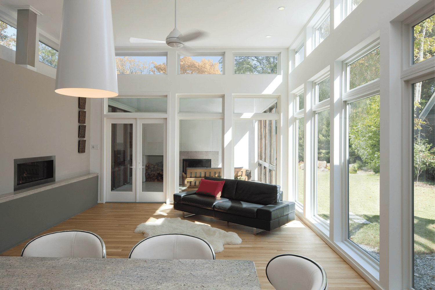 A spacious living room showcasing a central table with four chairs, complemented by warm decor and inviting ambiance.