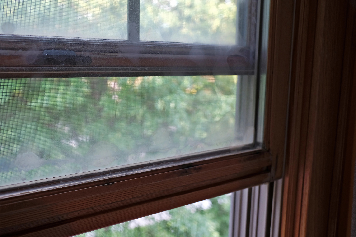  A wooden-framed window with a decorative sill, allowing natural light to enter the room.