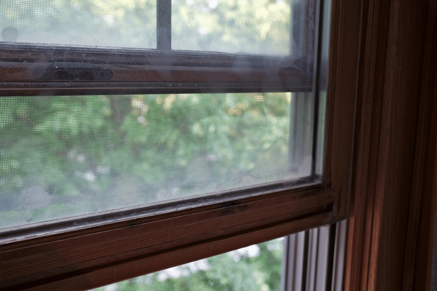 A wooden-framed window with a decorative sill, allowing natural light to enter the room.