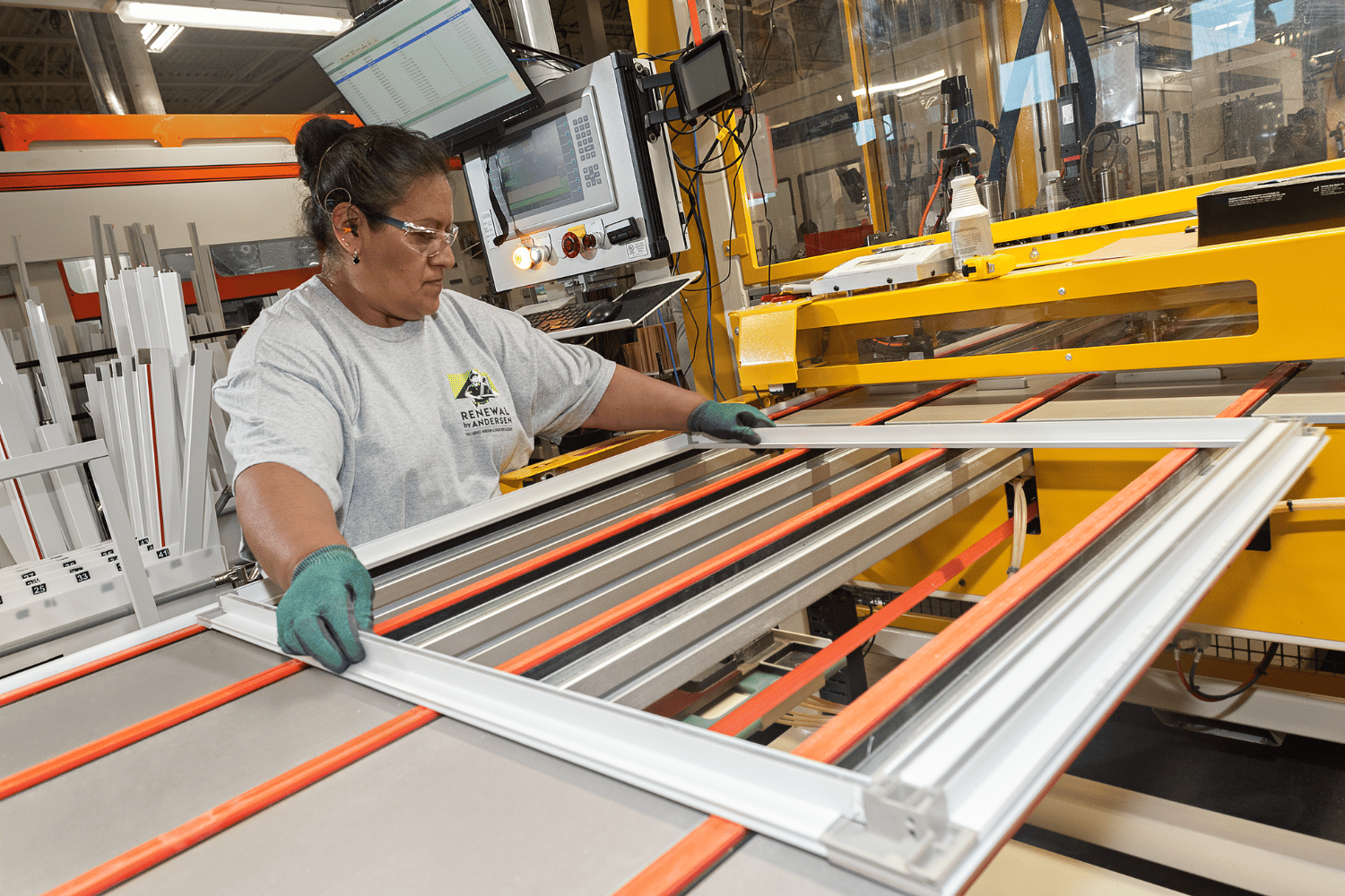 Person creating a window frame at a Renewal by Andersen manufacturing facility.
