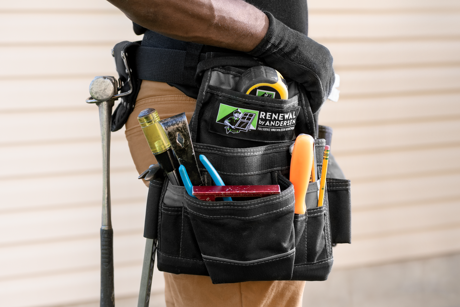 A Renewal by Andersen installer from the side. Close up on his tool belt. 