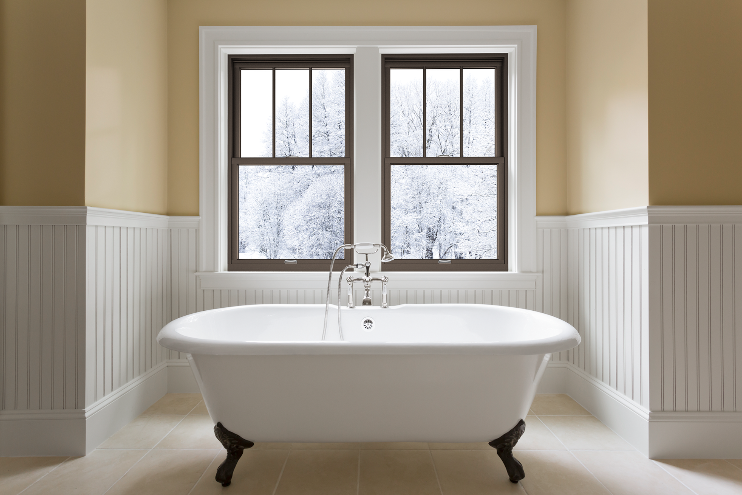 A white bathtub positioned in a bathroom beside a window, allowing natural light to illuminate the space.