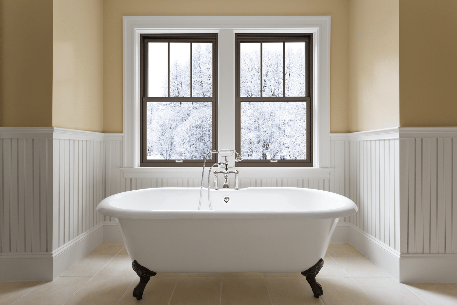 A white bathtub positioned in a bathroom beside a window, allowing natural light to illuminate the space.