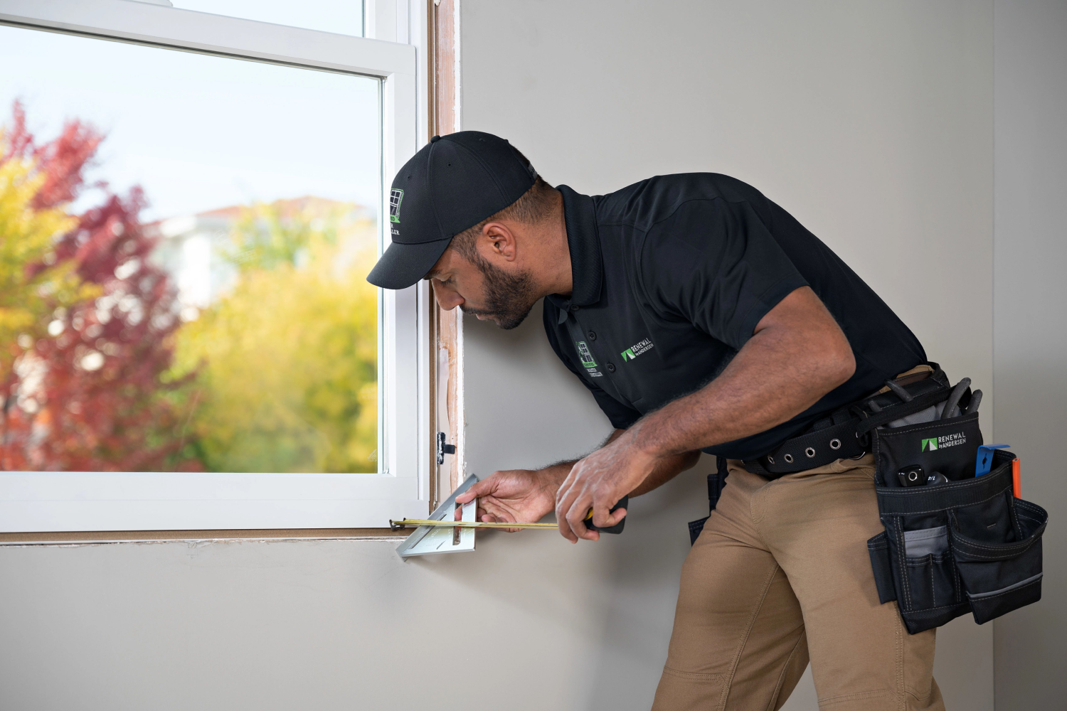 A Renewal by Andersen Installer measuring windows for installation