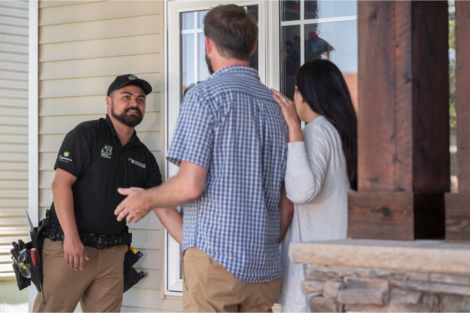 Renewal by Andersen Certified Master Installer talking with clients outside of their home.