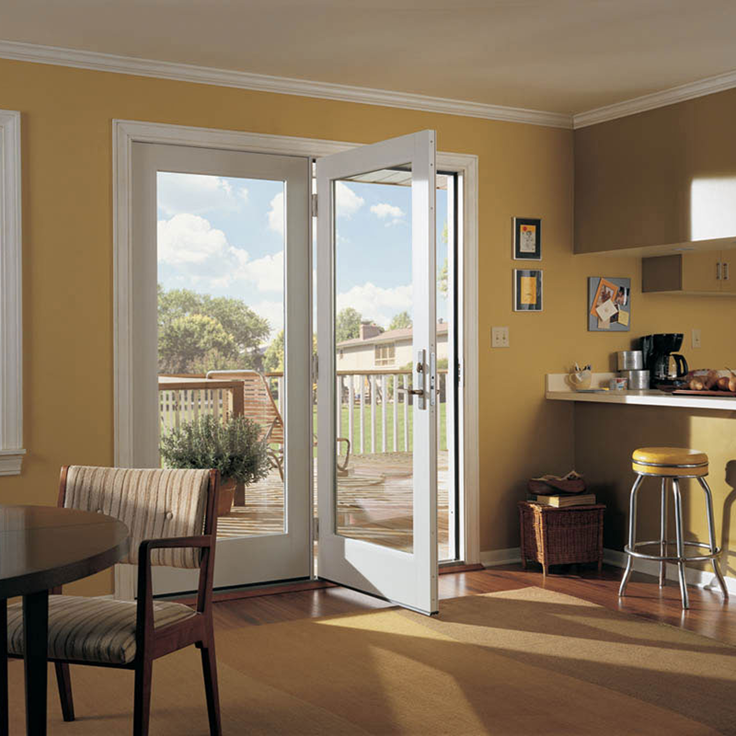 White french patio door in a yellow living room with a wood floor.