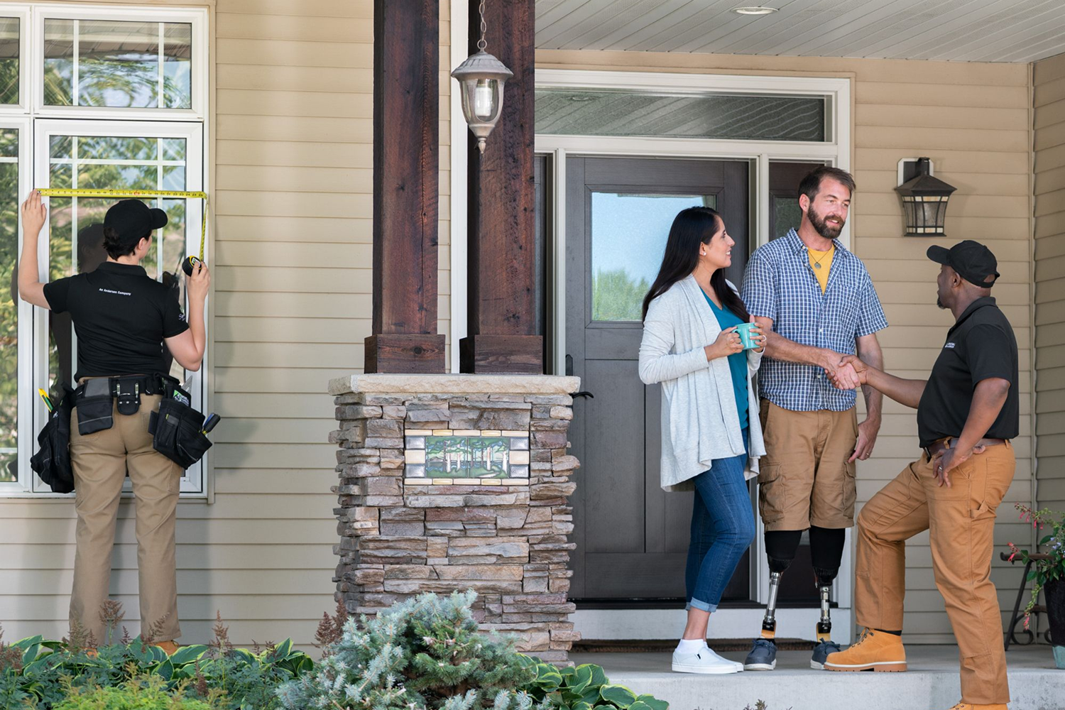 Renewal by Andersen Installation professionals working on windows and greeting homeowners.