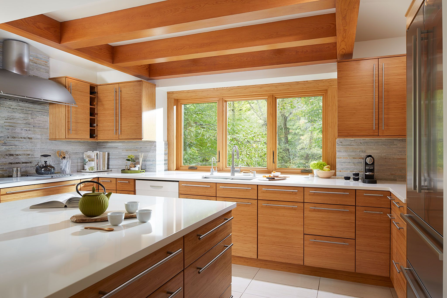 Modern kitchen featuring large Renewal by Andersen Fibrex picture windows with wood-grain interior finish, bringing natural light and scenic outdoor views into the space.