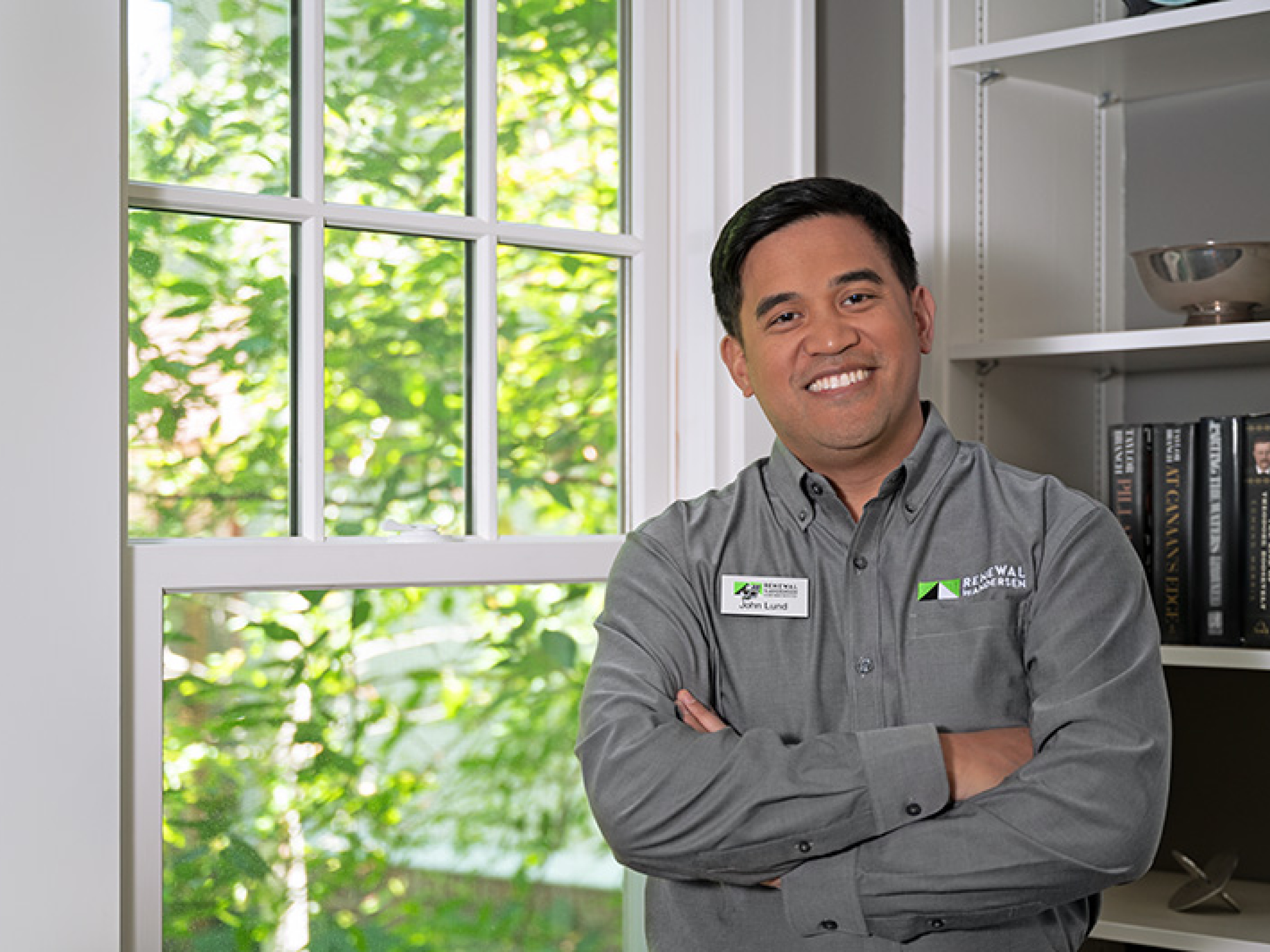 A design consultant standing next to a Renewal by Andersen window