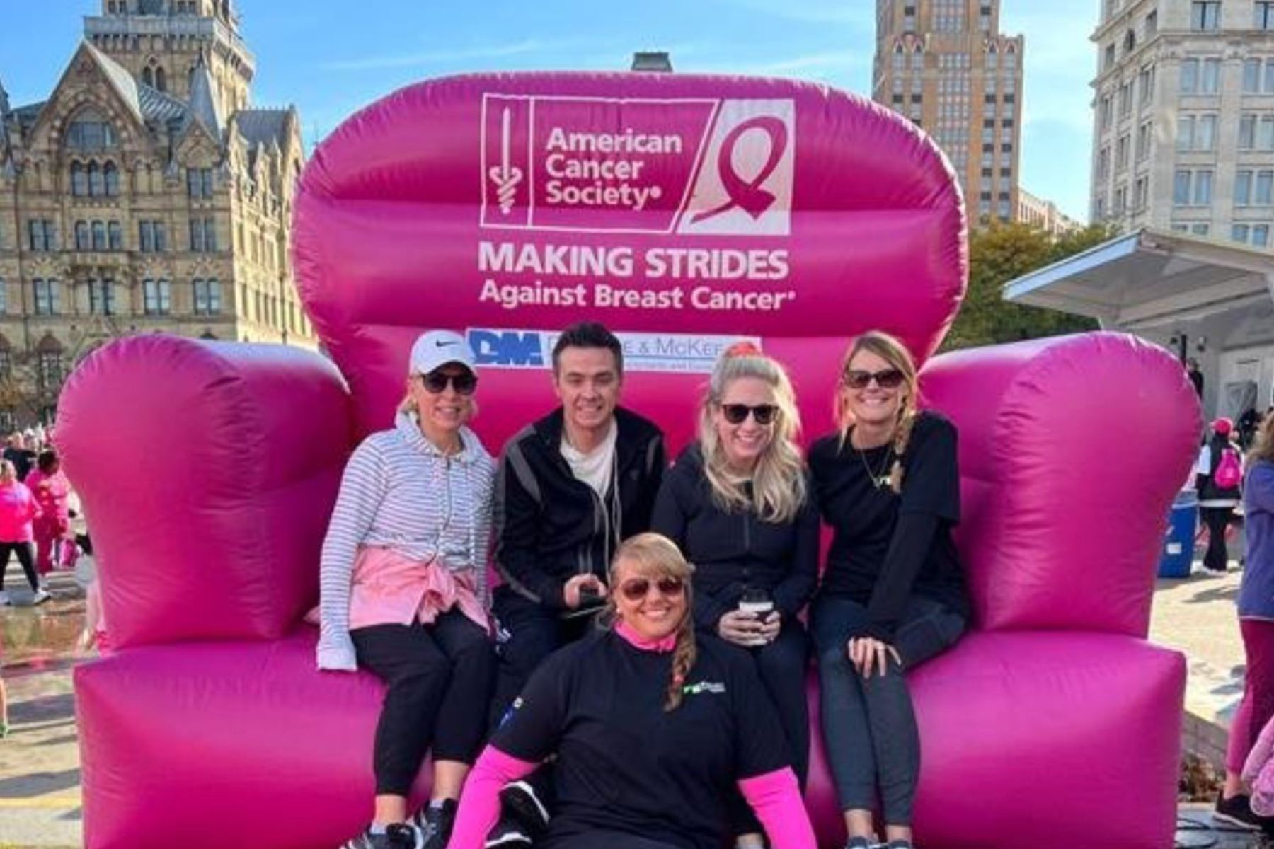 Group of RbA employees sitting on giant pink blow up chair