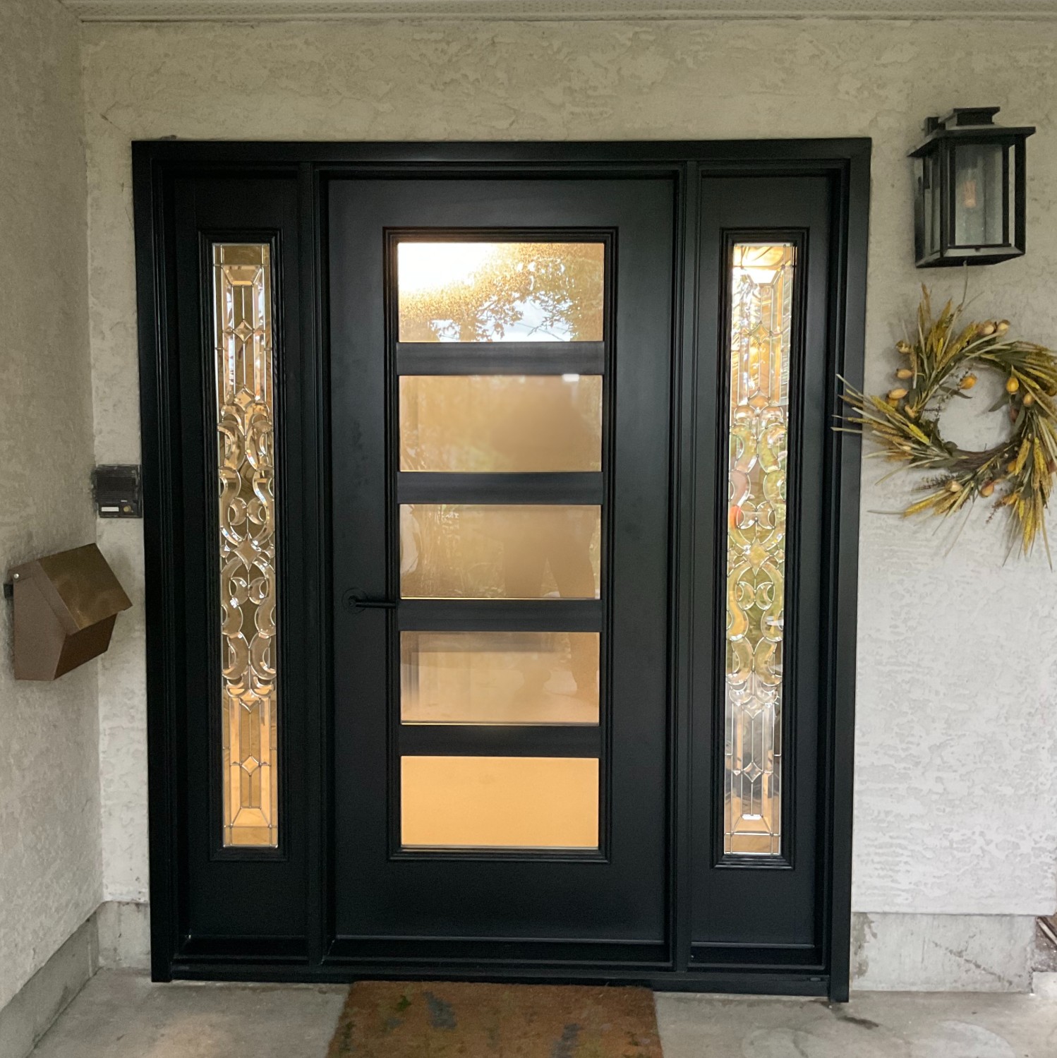 An Ensemble entry door with dual sidelights. This is a black modern style door with a full glass panel.