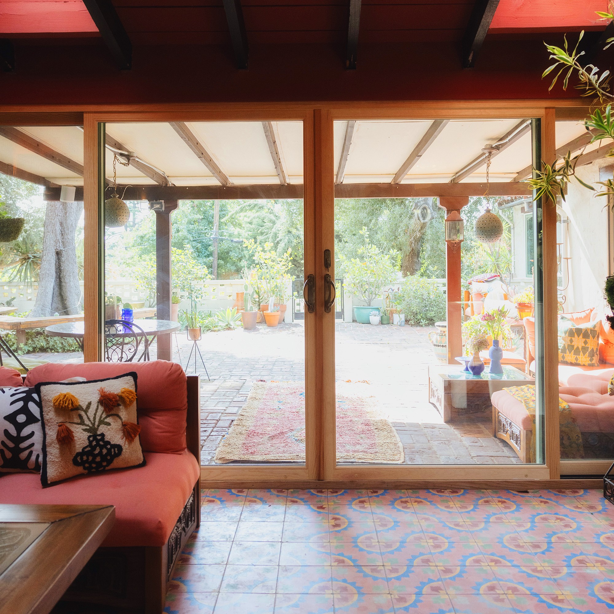 Pine finished sliding patio doors. Modern sliding patio doors looking over an atrium with a patterned tile floor.