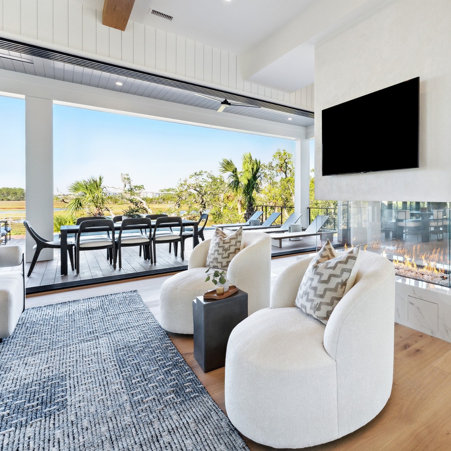 A coastal living rom with a multipanel sliding door and a fireplace.