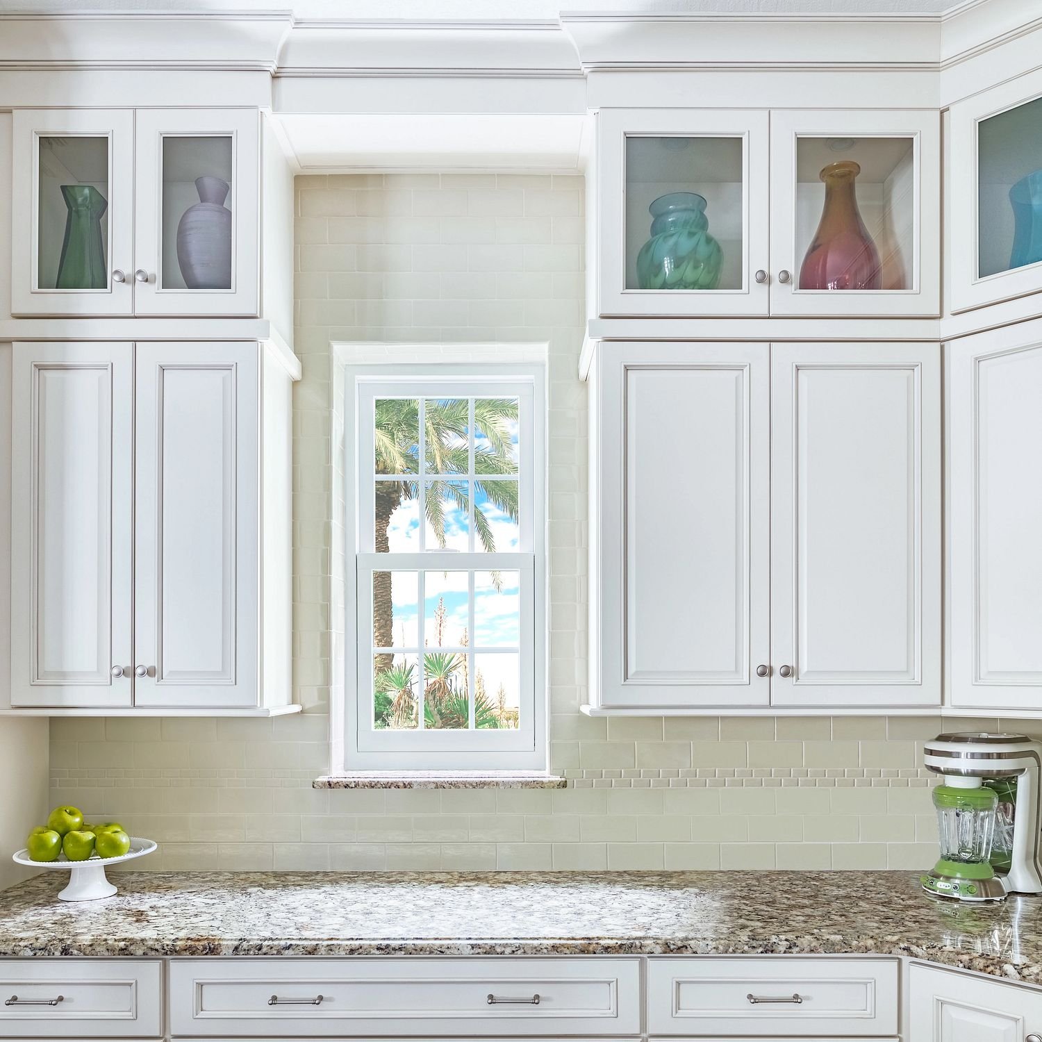 A small kitchen window between cabinets.