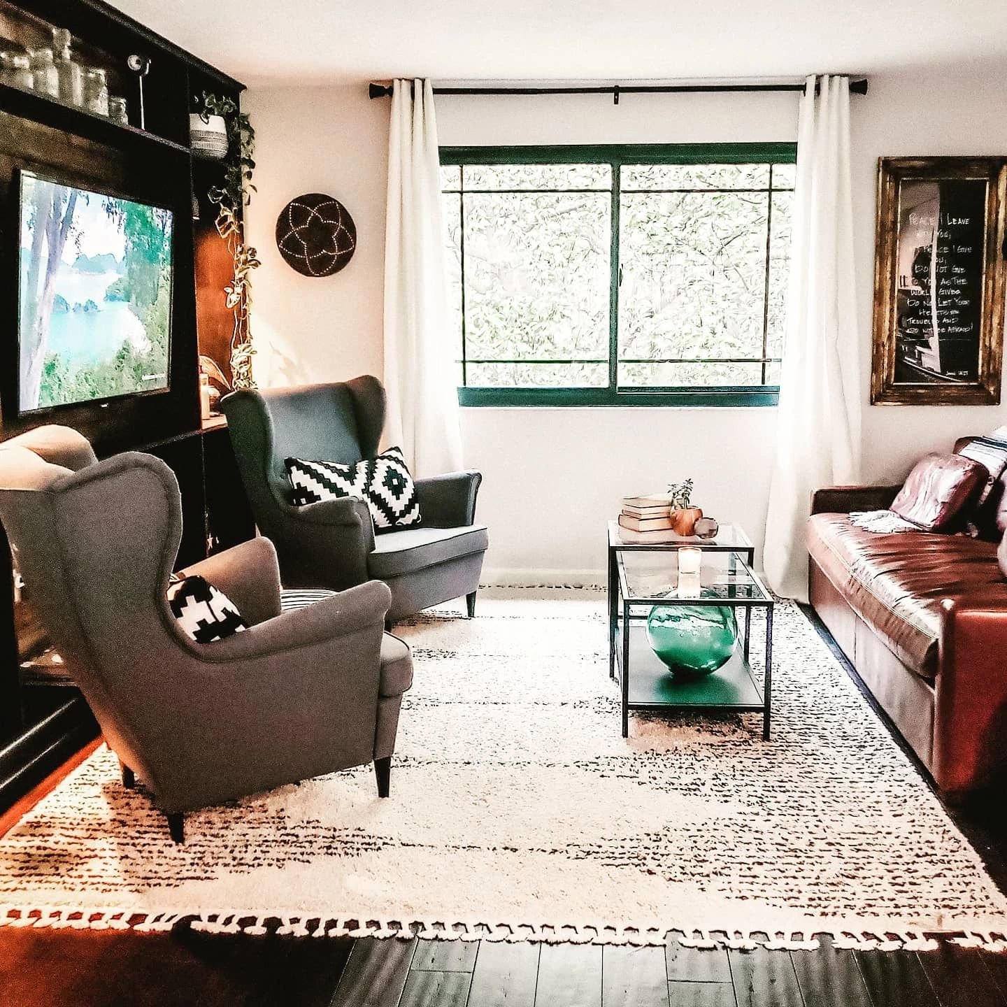 A family room with a black sliding window with prairie grilles.