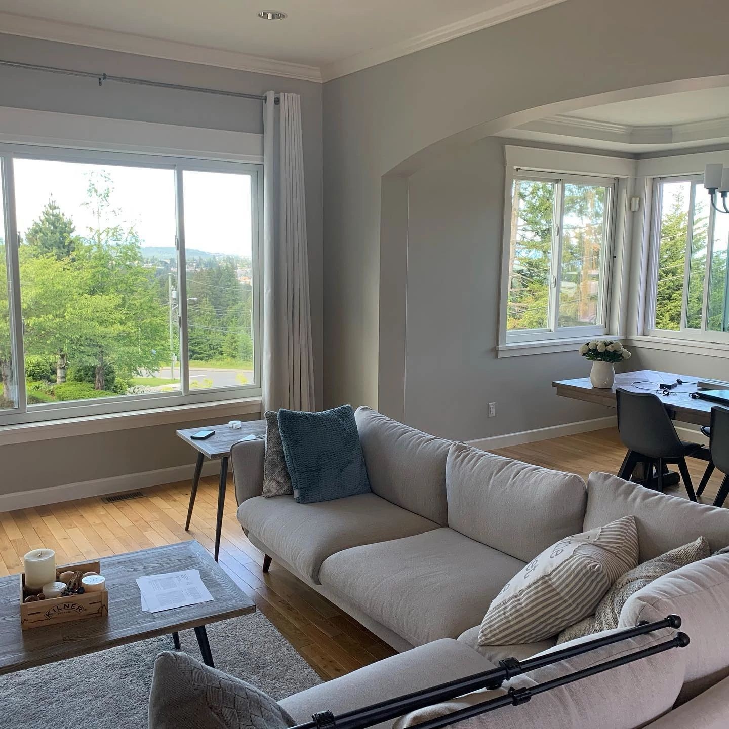 Living and dining rooms with a bank of gliding windows. The windows are white.