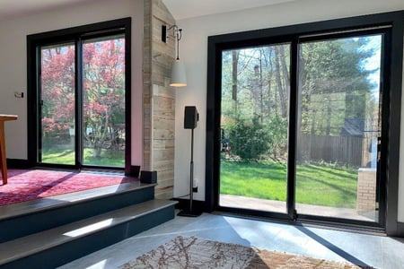The dining room and living room area in John's house. More rugs are visible.